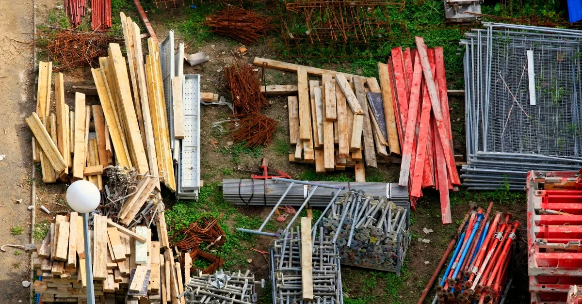 Reclaimed timber, scaffold and steel laid out across a site compound